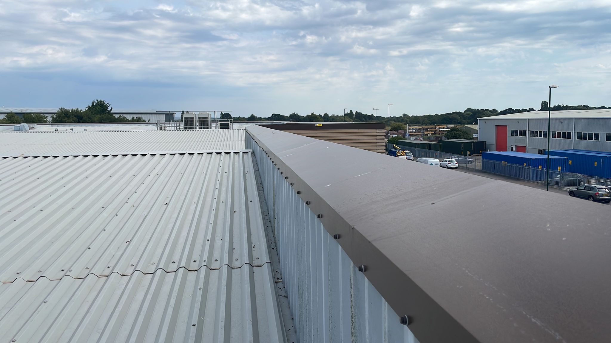 Wall capping flashings on an office and workshop roof in Bognor Regis, West Sussex
